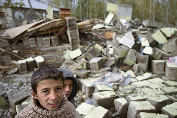 24 hours: Guvecli, Turkey: Two boys stand in front of a collapsed building 