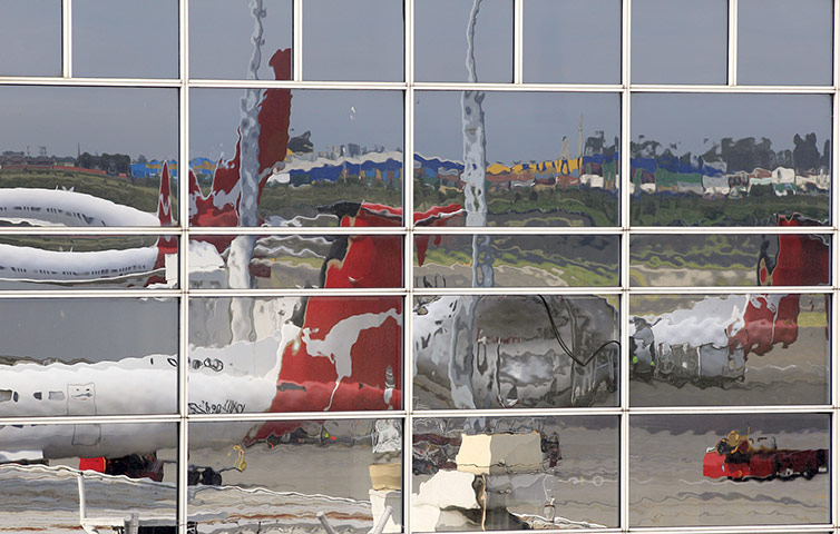 Qantas dispute: Idle Qantas planes are reflected in a window at Sydney Airport