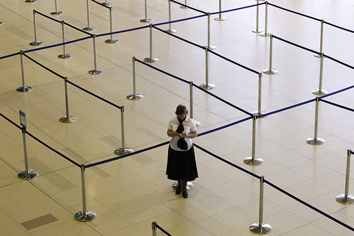 Qantas dispute: A woman reads her book at the check-in line of a Qantas flight