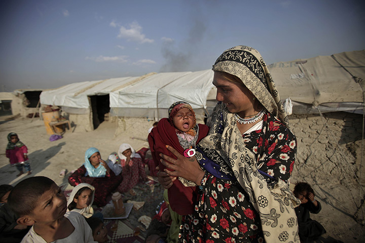 24 hours: Kabul, Afghanistan: An Afghan woman holds her three-week-old daughter Mjdah