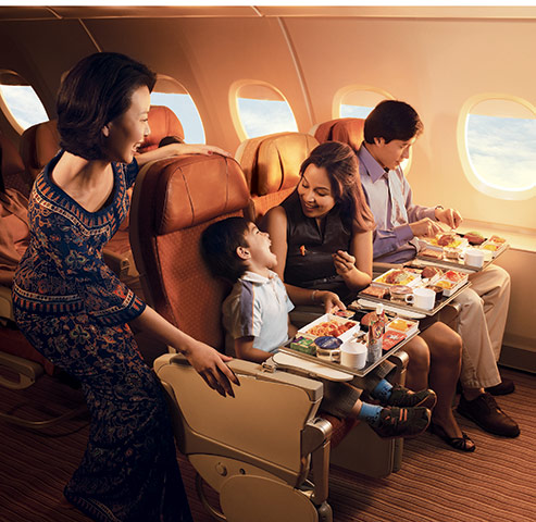 Singapore Airlines: Cabin crew with passengers on a Singapore flight