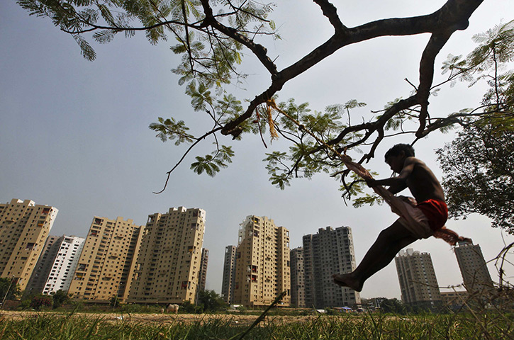 24 hours: Kolkata, India: A boy plays on a swing suspended from a tree