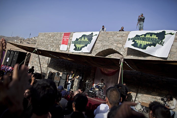 FTA: Ahmad Masood: An Afghan policeman on top of a wall uses his mobile phone to film