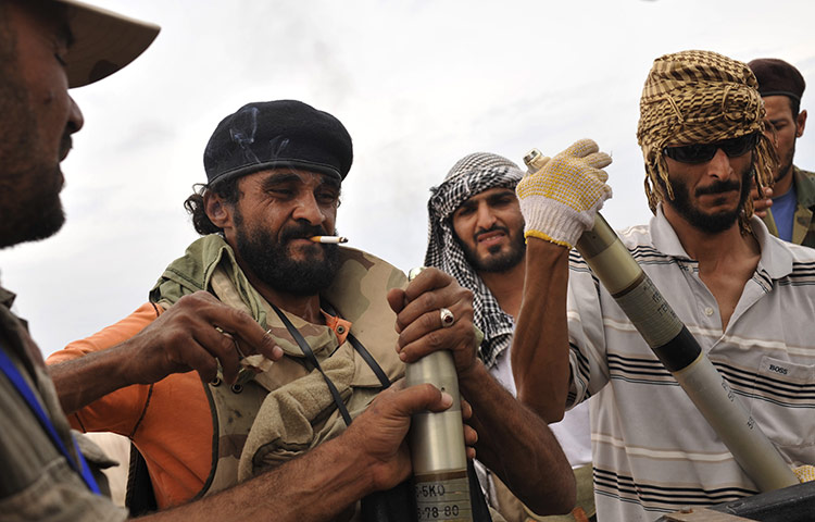 Sirte final assault: Libyan revolutionary fighters assemble missiles during an attack for Sirte