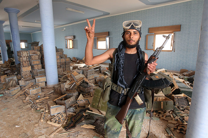 Sirte final assault: An NTC fighter flashes the victory sign after finding a weapons depot 