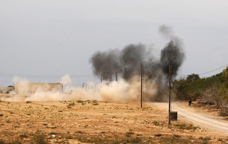 Sirte final assault: An anti-Gaddafi fighter runs to take cover from incoming shelling