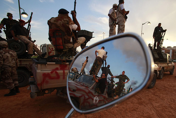 24 hours: Tripoli, Libya: Anti-Gaddafi fighters are reflected in a motorbike mirror