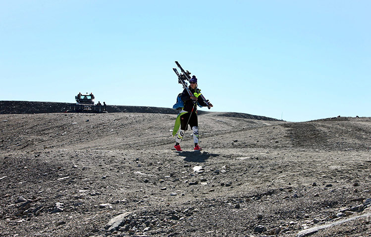 24 hours: Flattach, Austria: Alpine ski racer walks over snowless ground
