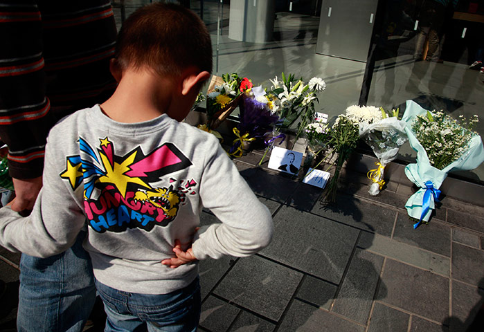 Steve Jobs Apple shrines: Beijing, China: A child looks at flowers laid in tribute to Steve Jobs
