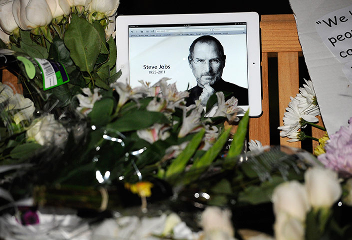 Steve Jobs Apple shrines: Cupertino, California:  Flowers and an iPad showing a picture of Steve Jobs