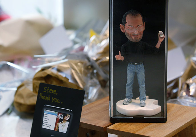 Steve Jobs tributes: Hong Kong: A figure of Steve Jobs and flowers are laid at an Apple store