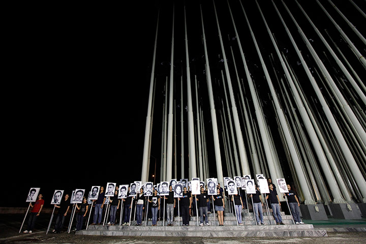 24 hours: Havana, Cuba: Cubans hold photographs of victims of Cubana Flight bombing