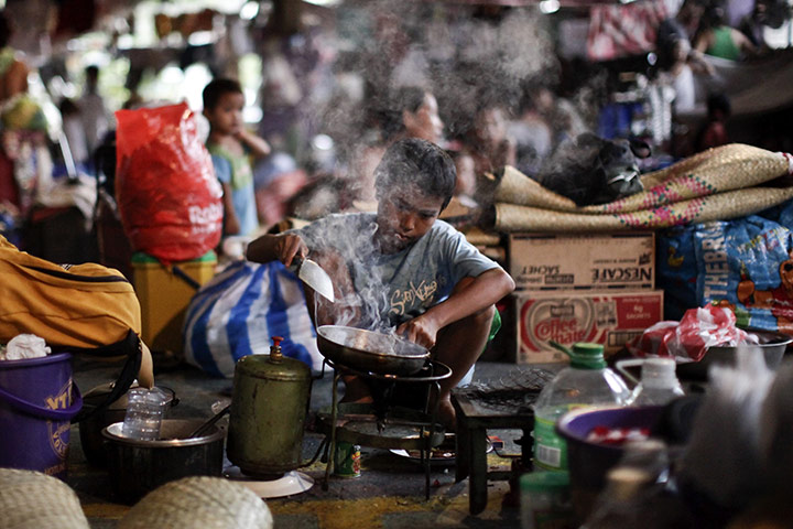 24 hours in pictures: Navotas City, Philippines: A boy cooks for his family