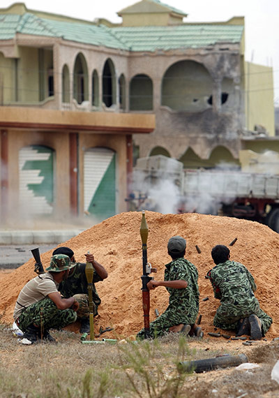 The battle for Sirte: Anti-Gaddafi fighter take position during a street battle in Sirte