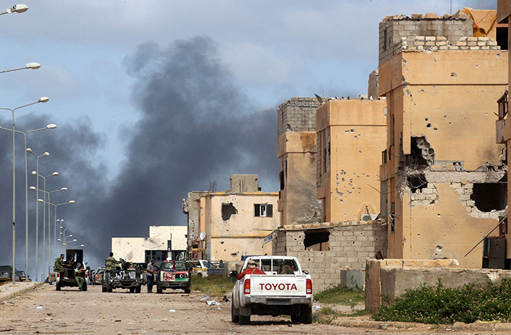 sirte: Rebels drive past damaged buildings