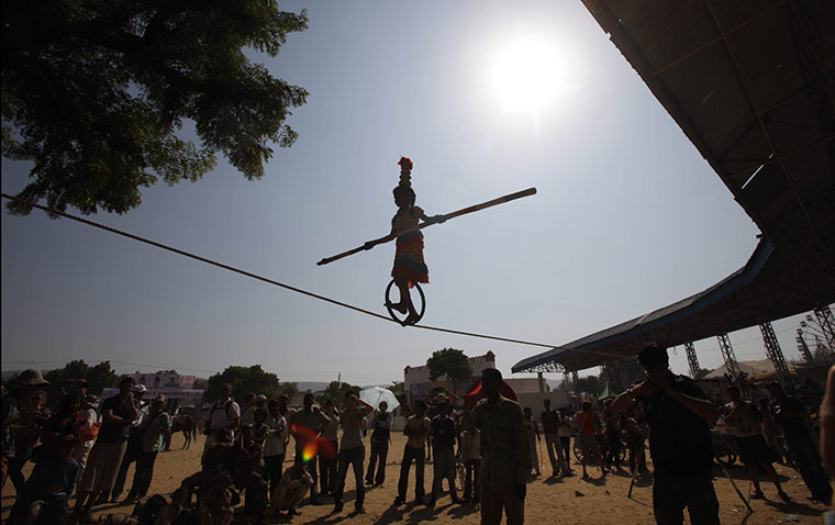 FTA: Manish Swarup: Tourists watch as a girl performs rope tricks at the Pushkar fair
