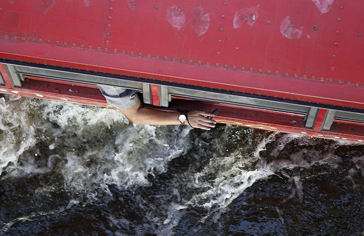 24 hours in pictures: A Thai bus passenger on bus through flooded street