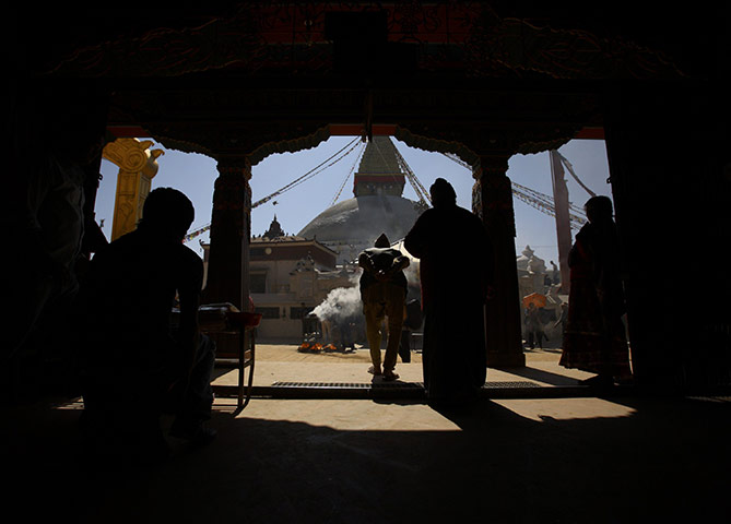 24 hours in pictures: Locals of Boudha are silhouetted against the Boudhanath Stupa in Kathmandu