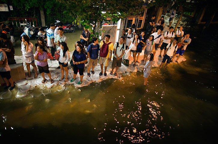 24 hours in pictures: Bangkok, Thailand: Commuters wait for a bus