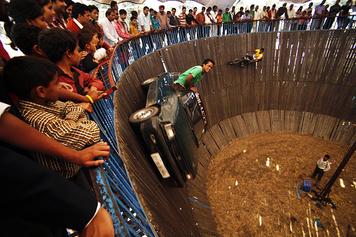 24 hours in pictures: Jammu, India: Performers ride vehicles on the Well of Death