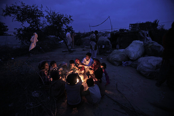 24 hours in pictures: Islamabad, Pakistan: People in a slum gather around a fire