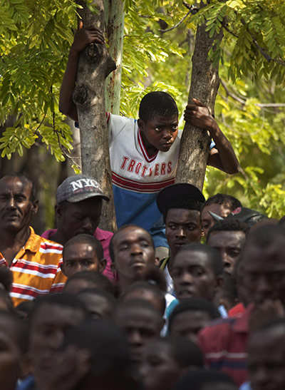 24 Hours: A group listens to a speech by Haiti's President Michel Martelly