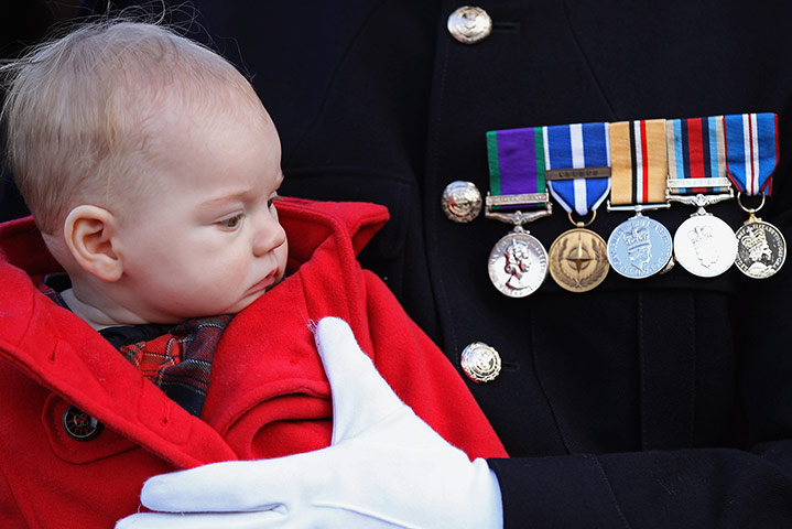 Remembrance Sunday: A Royal Marine Corporal holds his son as they attend a remembrance ceremony