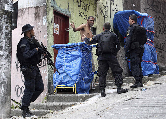 Rio raid: officers check a suspect