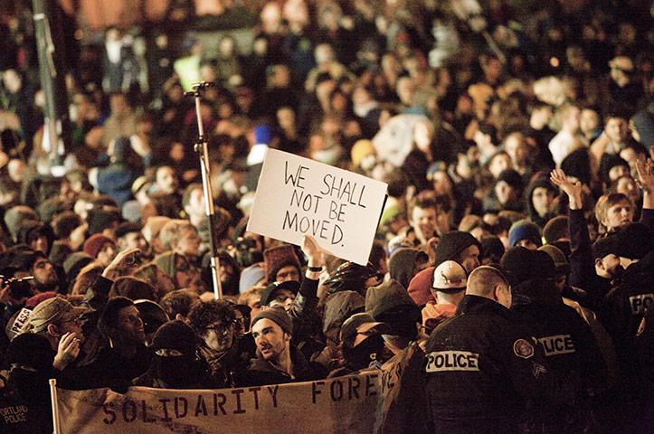 Occupy Portland: Protesters at the camp chant slogans and hold up signs