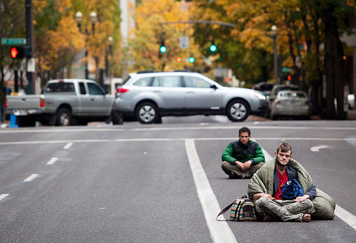 Occupy Portland: Protesters sit in the middle of a road in defiance of police instructions
