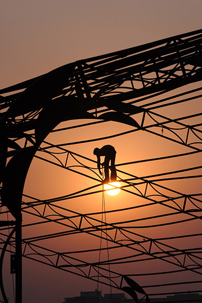 24 hours in pictures: An Indian labourer erects a temporary structure