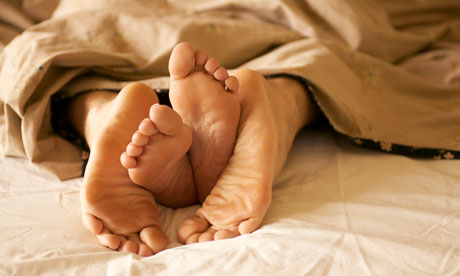 Feet of couple in bed