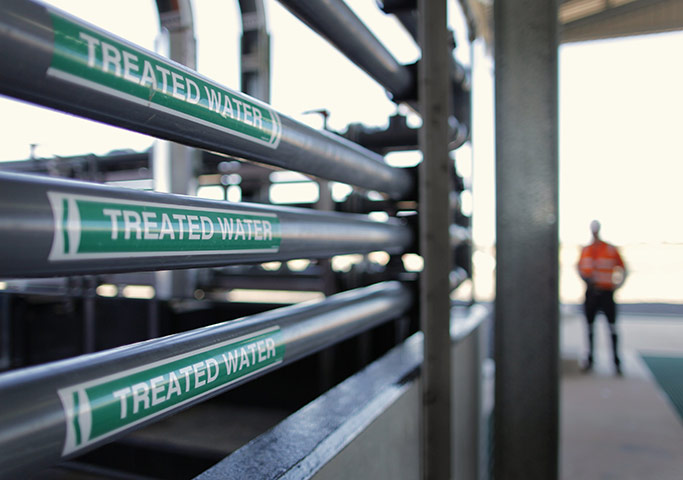 From the agencies: A worker stands near a filtration equipment at a QGC reverse