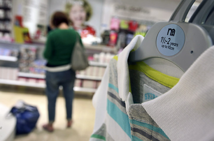 Week in business: A customer stands near a display of children's clothes in a Mothercare