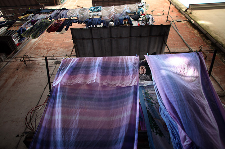 24 hours in pictures: A woman hangs out washing in a densely populated alleyway in Naples