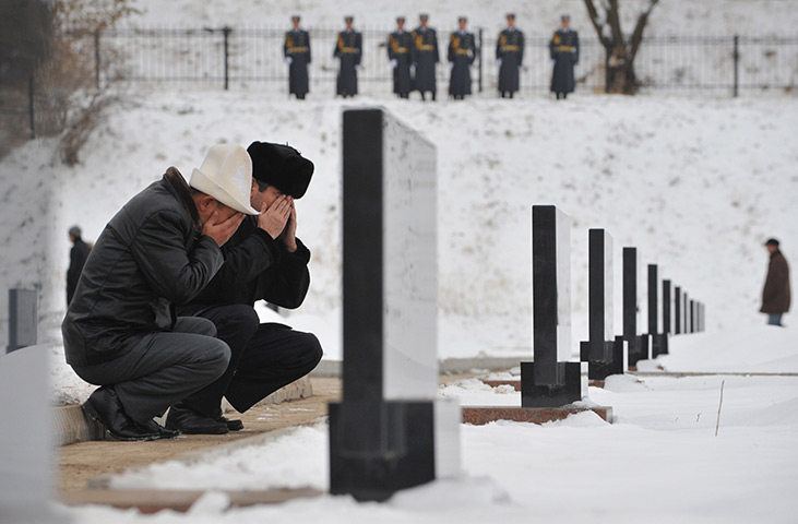 24 hours in pictures: Kyrgyz people pray at Ata-Beyit cemetery at the graves of their relatives