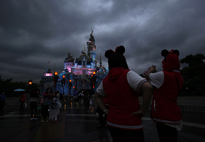 24 hours in pictures: A girl takes a photo of the castle lit up at Hong Kong Disneyland