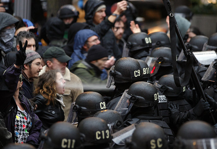 24 hours in pictures: Portland, US: A police officer uses pepper spray