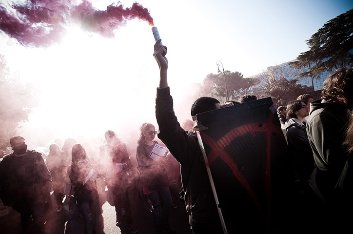 24 hours in pictures: Rome, Italy: Protesters light flares as they take to the streets
