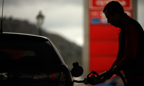 A worker pumps petrol into a customer's car at a petrol station