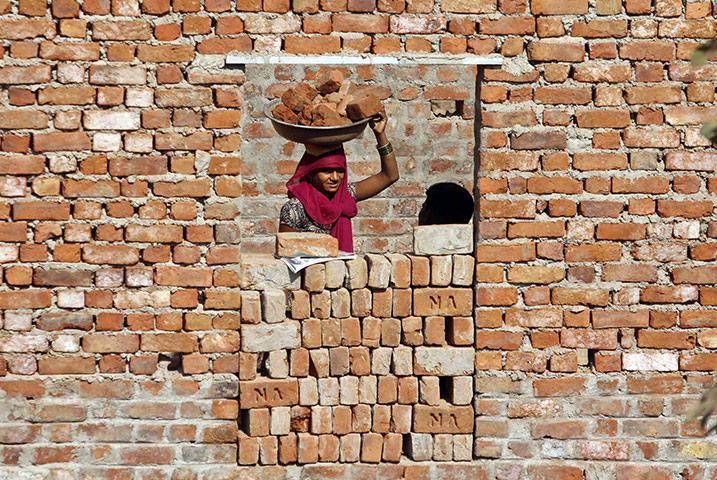 24 hours: A construction labourer carries bricks on her head in Ahmedabad