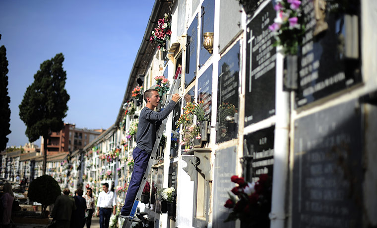 All saints day: A man works during All Saints Day in a cemetery, Spain