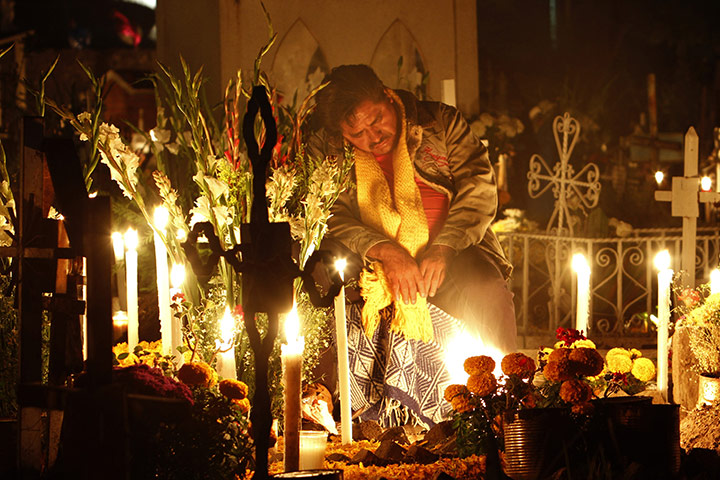 All saints day: A man rests at the grave site during Day of the Dead, Mexico