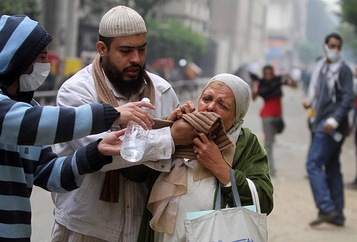 Tahrir square: A woman reacts to tear gas during clashes in Tahrir Square