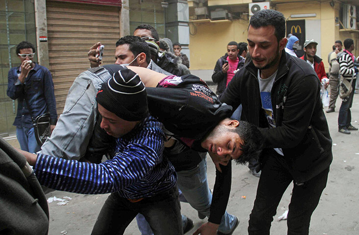 Tahrir square: Protesters evacuate a wounded man in Tahrir Square