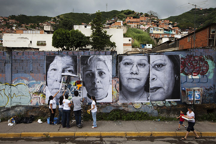 24 hours in pictures: Volunteers put up large portraits of women, in Caracas
