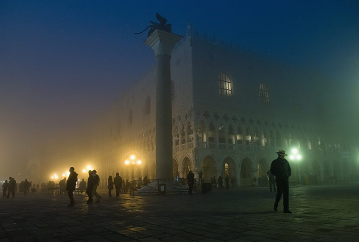 24 hours in pictures: A gondolier walks in St Mark's Square as thick fog shrouds Venice