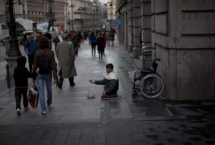 24 hours in pictures: A disabled man begs in the street in Madrid