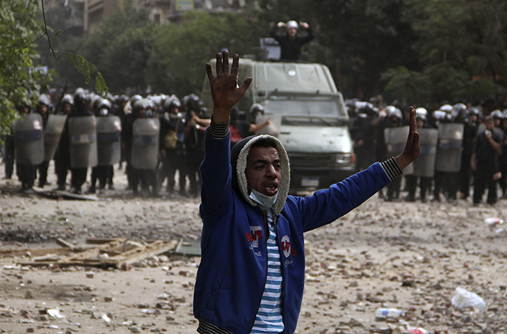 Cairo protests: A protester gestures to stop throwing stones at riot police, Cairo