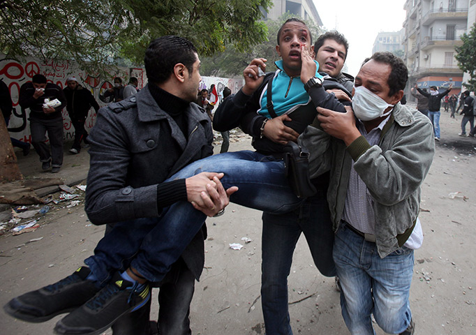Cairo protests: An injured protester is taken way during clashes with security forces